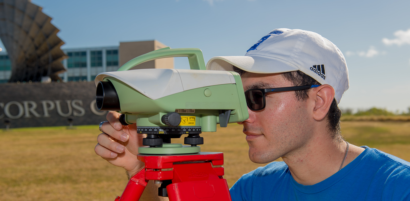 student looking through a camera equipment
